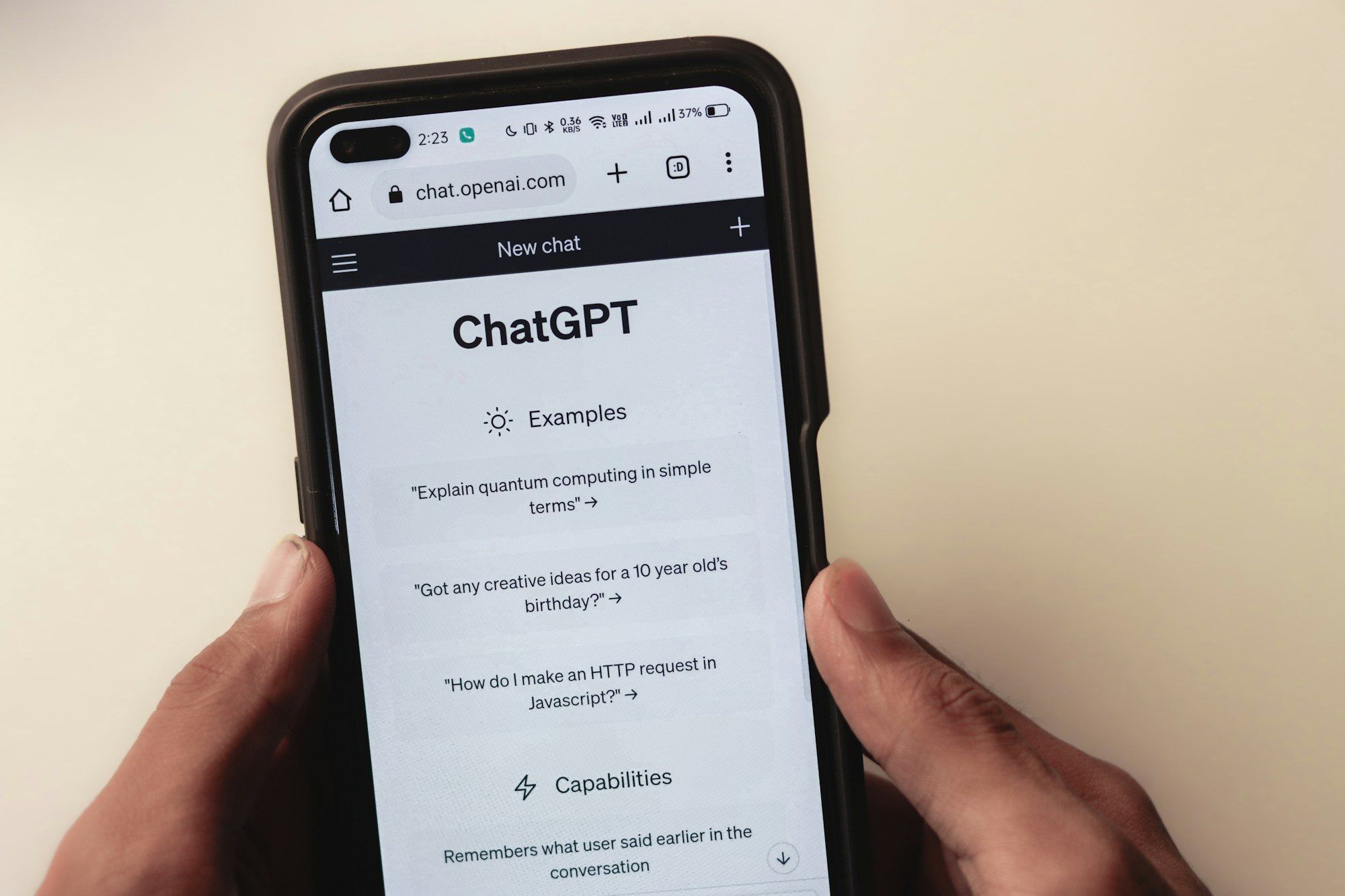 En hand håller en mobil med en AI-chatt öppen